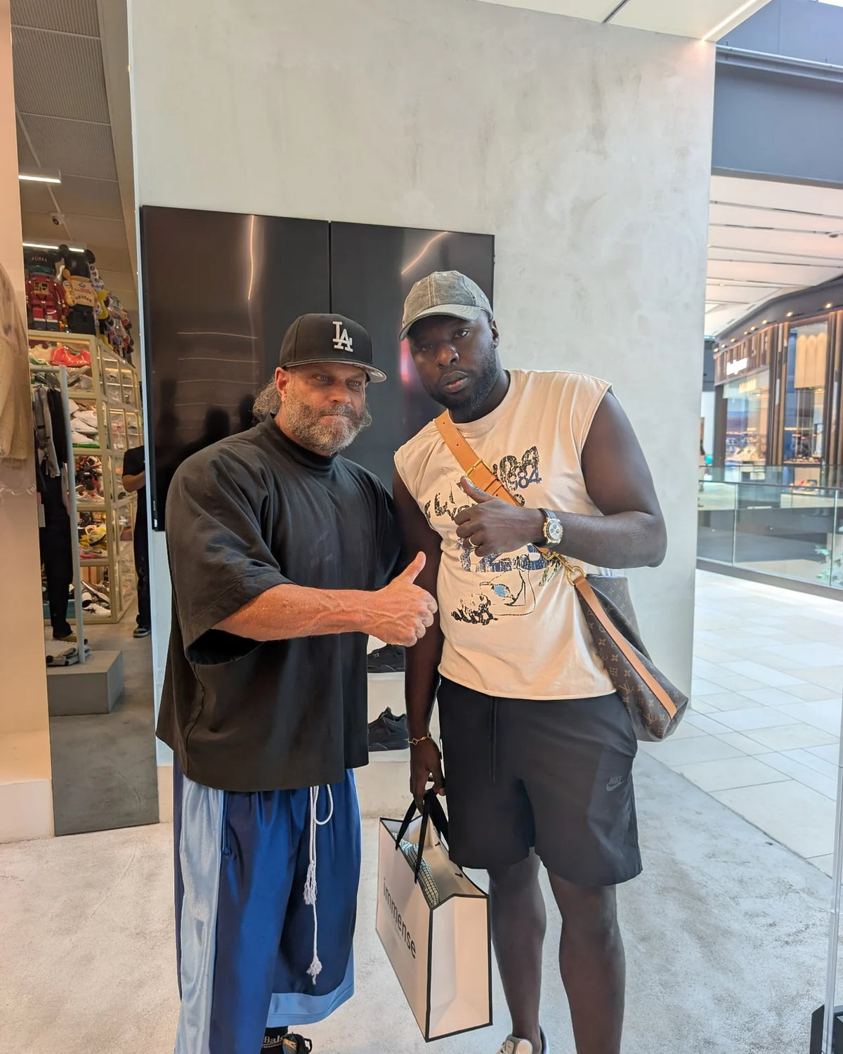 Two customers with an Immense Galerie shopping bag at the Royalmount store