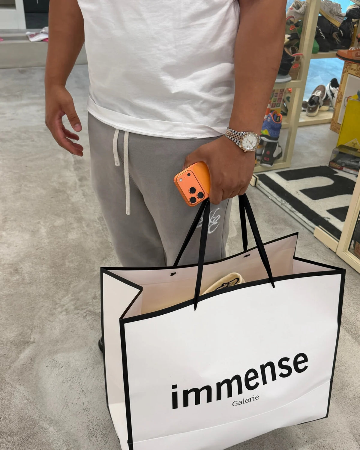 Customer carrying a large Immense Galerie shopping bag in store